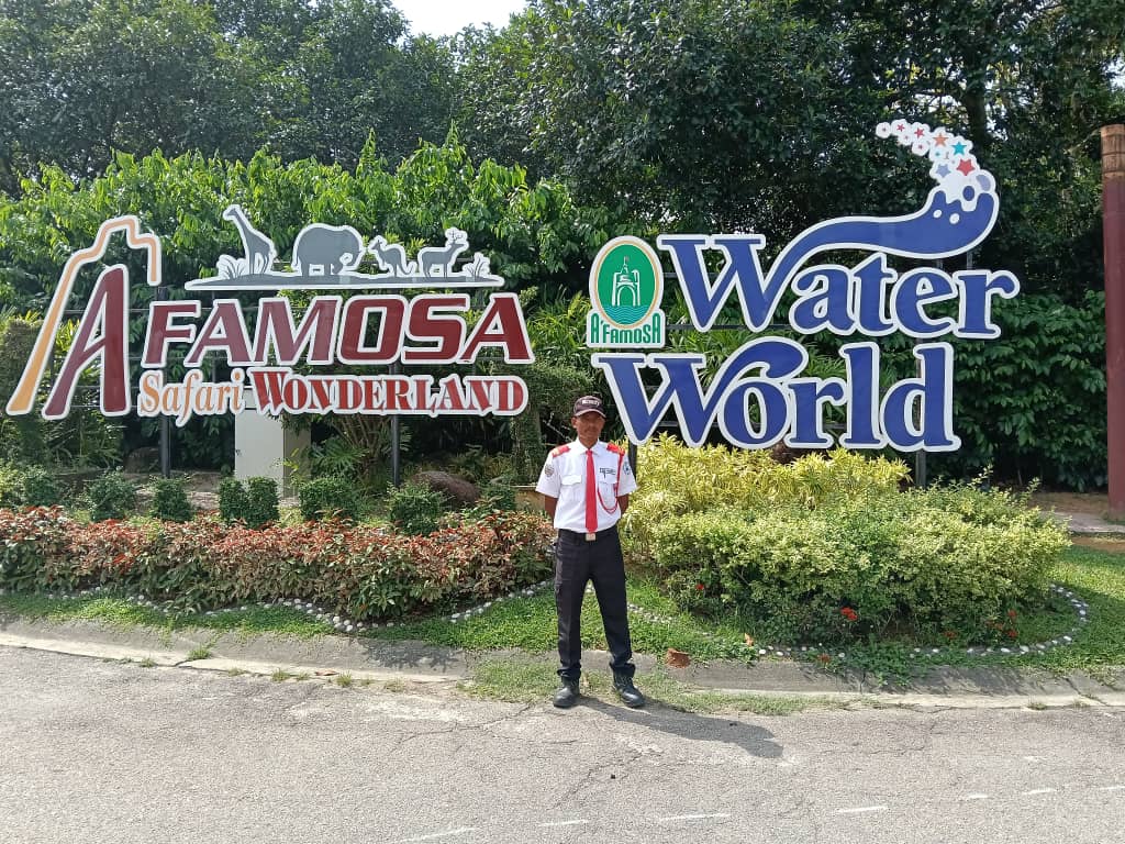 KSD Security guard standing in front of the A'Famosa Safari Wonderland and Water World attraction signage in Melaka.