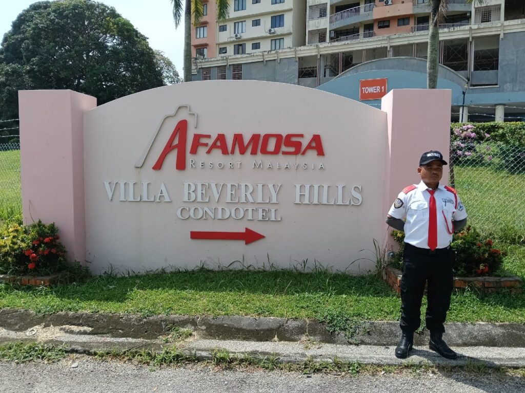 KSD Security guard standing beside the A'Famosa Resort Villa Beverly Hills Condotel signage in Melaka.