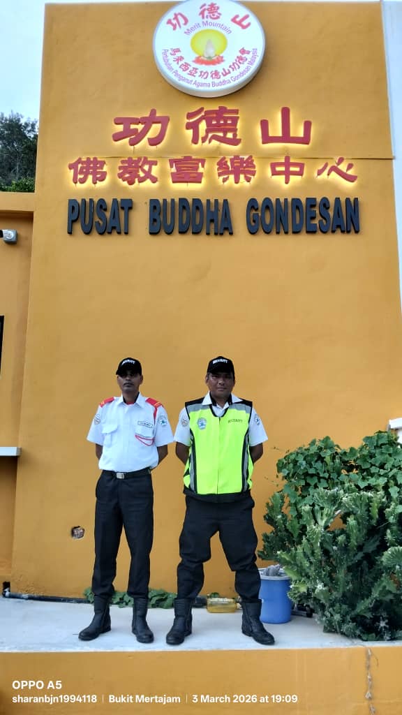 Two KSD Security guards standing in front of the Pusat Buddha Gondesan temple signage at Bukit Mertajam under the temple guardian service.