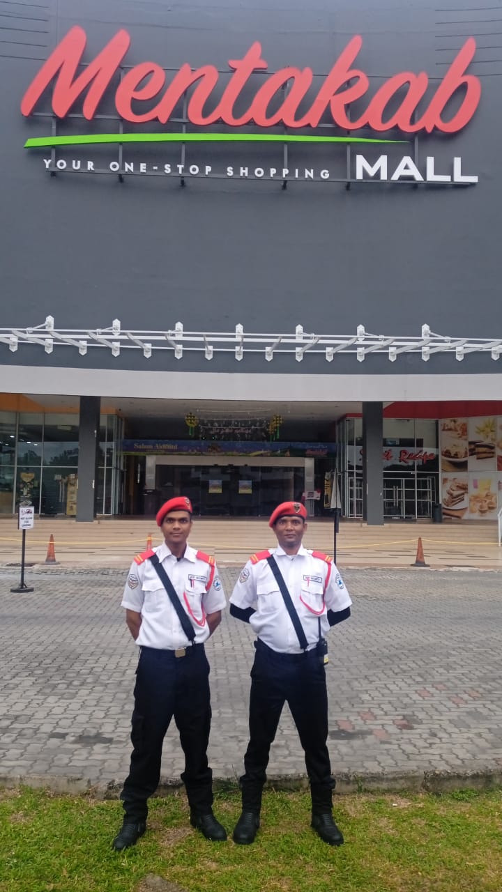 Two KSD Security guards in white shirts and red berets posted in front of the Mentakab Mall main entrance.
