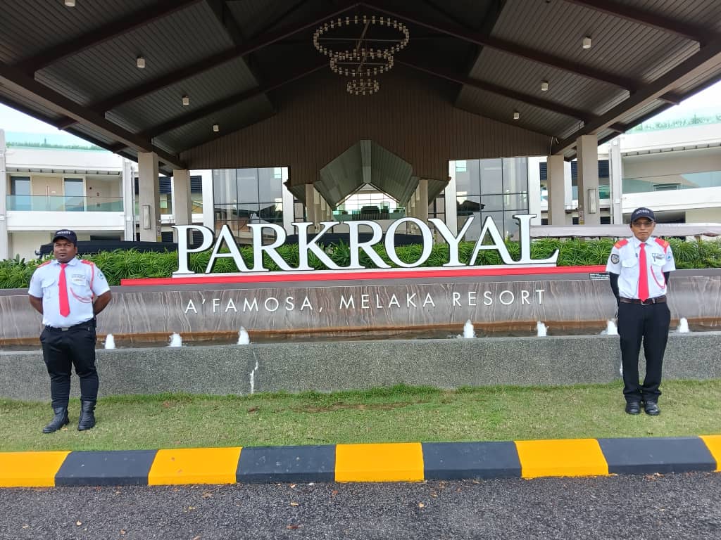 Two KSD Security guards posted on either side of the PARKROYAL A'Famosa Melaka Resort entrance signage and fountain.