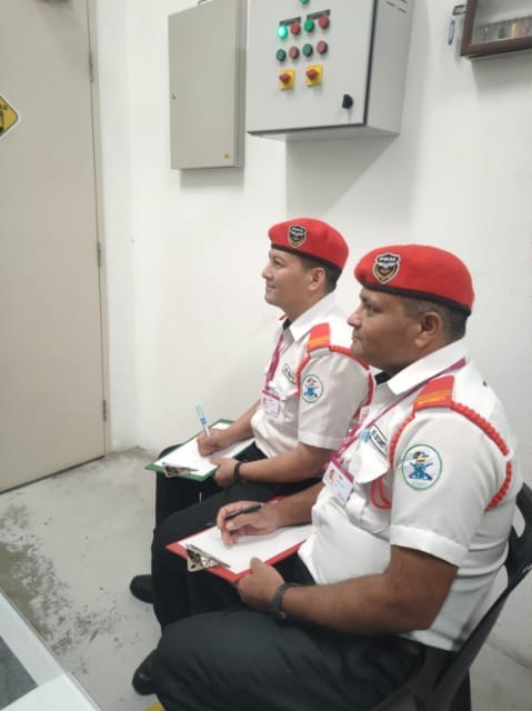 Two KSD Security guards in red berets taking notes during the mall security training class at AEON Falim